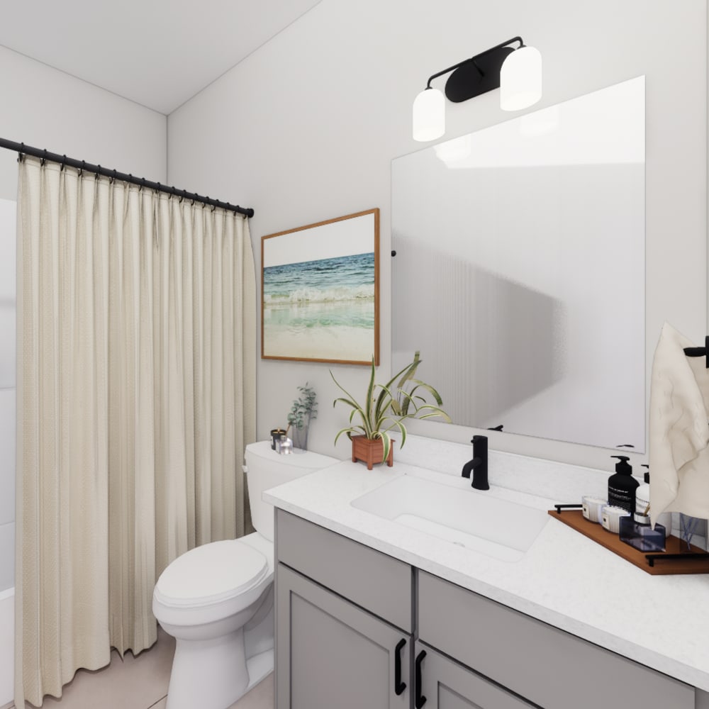 Bright bathroom with vanity light, mirror, sink , commode and bathtub at The Pointe at Loudon in Loudon, Tennessee