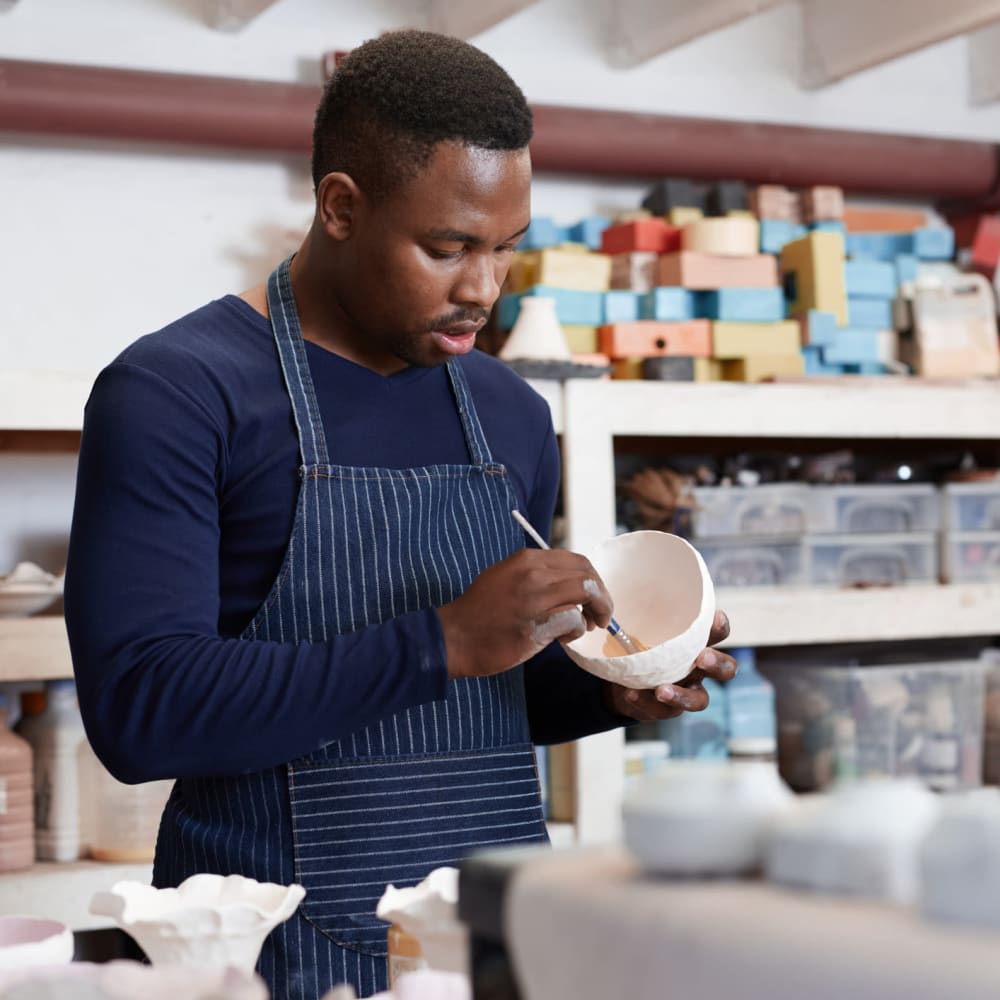 Man painting his pottery at 1510 Belleville in Richmond, Virginia