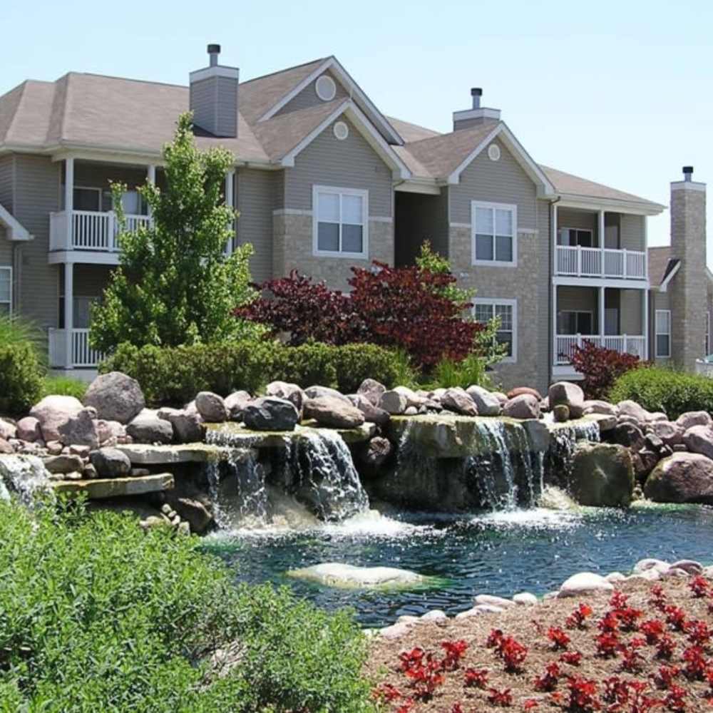 Charming property featuring lush landscaping and a tranquil waterfall feature at Boulder Springs in Maryland Heights, Missouri.