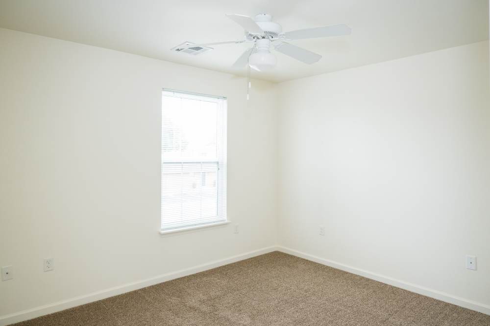 Charming bedroom with soft carpet and ample natural light at Cascade Villas in Wichita Falls, Texas.