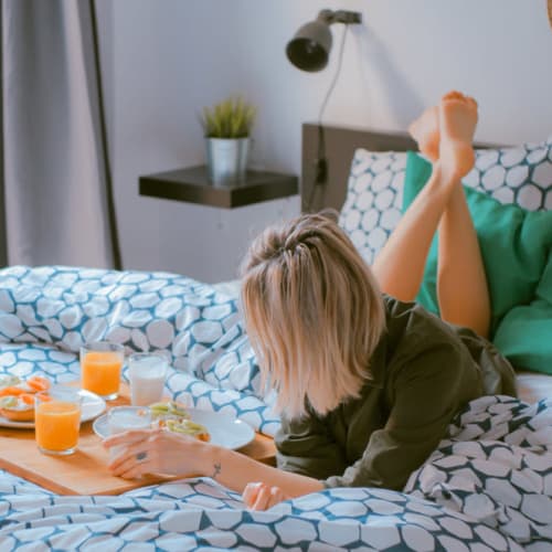 A resident eating breakfast in bed at The One Atlantic in Stamford, Connecticut