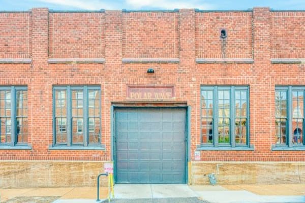 Exterior of industrial brick building with large windows and garage door