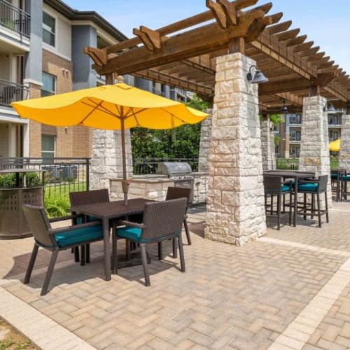 Covered seating and grilling stations by the pool at 33Hundred in Austin, Texas