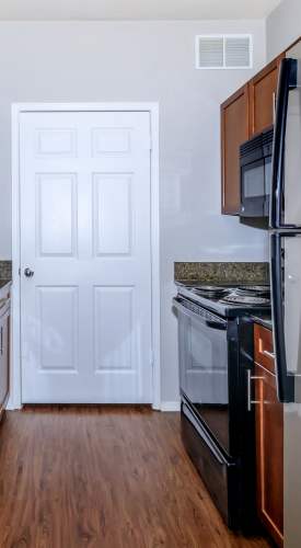 Apartment kitchen with wood-style flooring at One Belmar Place in Lakewood,Colorado
