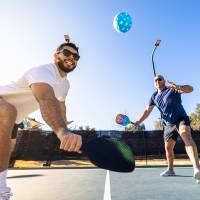 Men playing pickleball at community court at Sagamore Apartments in Benbrook, Texas