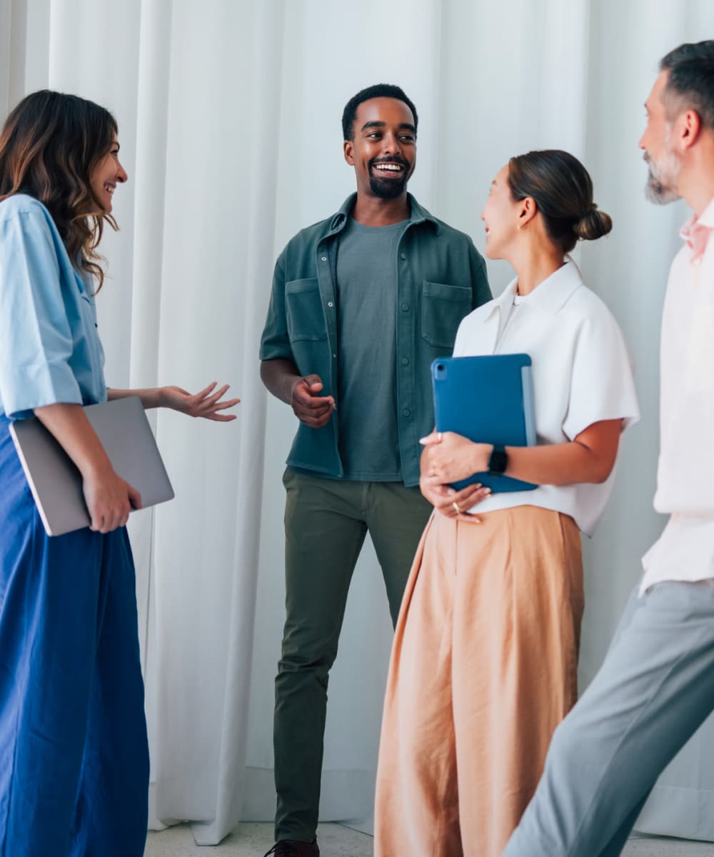  Four colleagues talking at the office at ARTISAN Management Group in Des Moines, Iowa