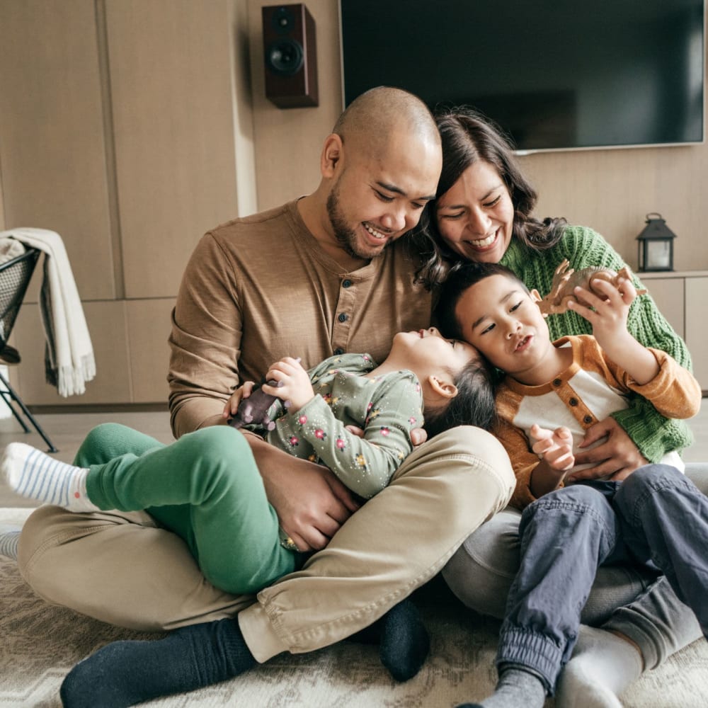 Happy family sitting in their living room at Wellington Point in Atlanta, Georgia