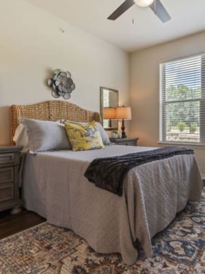 Model bedroom with a ceiling fan at Auberge of Tyler in Tyler, Texas
