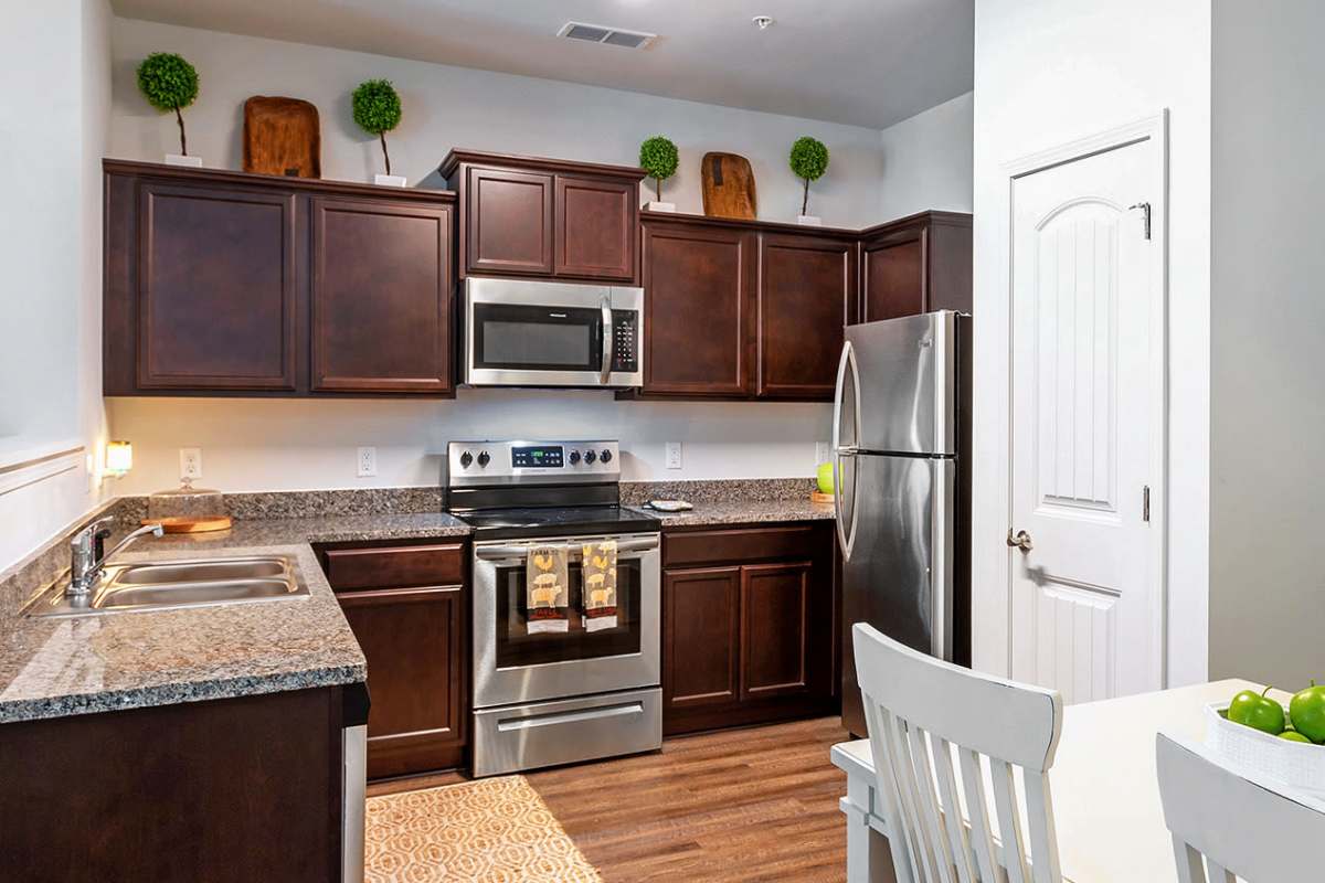 Modern kitchen with wood-style flooring at Latitude at Richmond Hill in Richmond Hill, Georgia