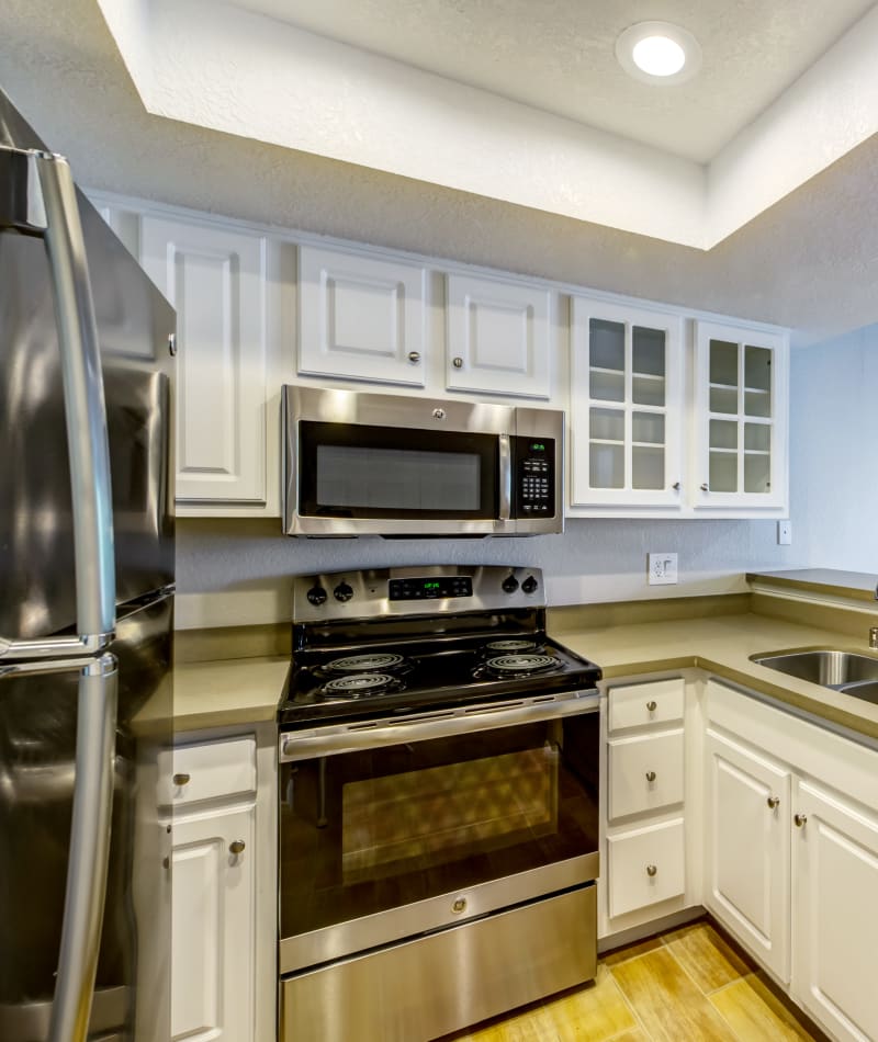 Modern kitchen with sleek, stainless-steel appliances and a dual-basin sink in a model home at Sofi Irvine in Irvine, California