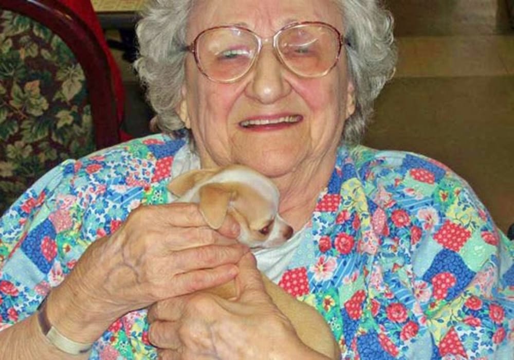 Happy resident holding a puppy at Holton Manor in Elkhorn, Wisconsin