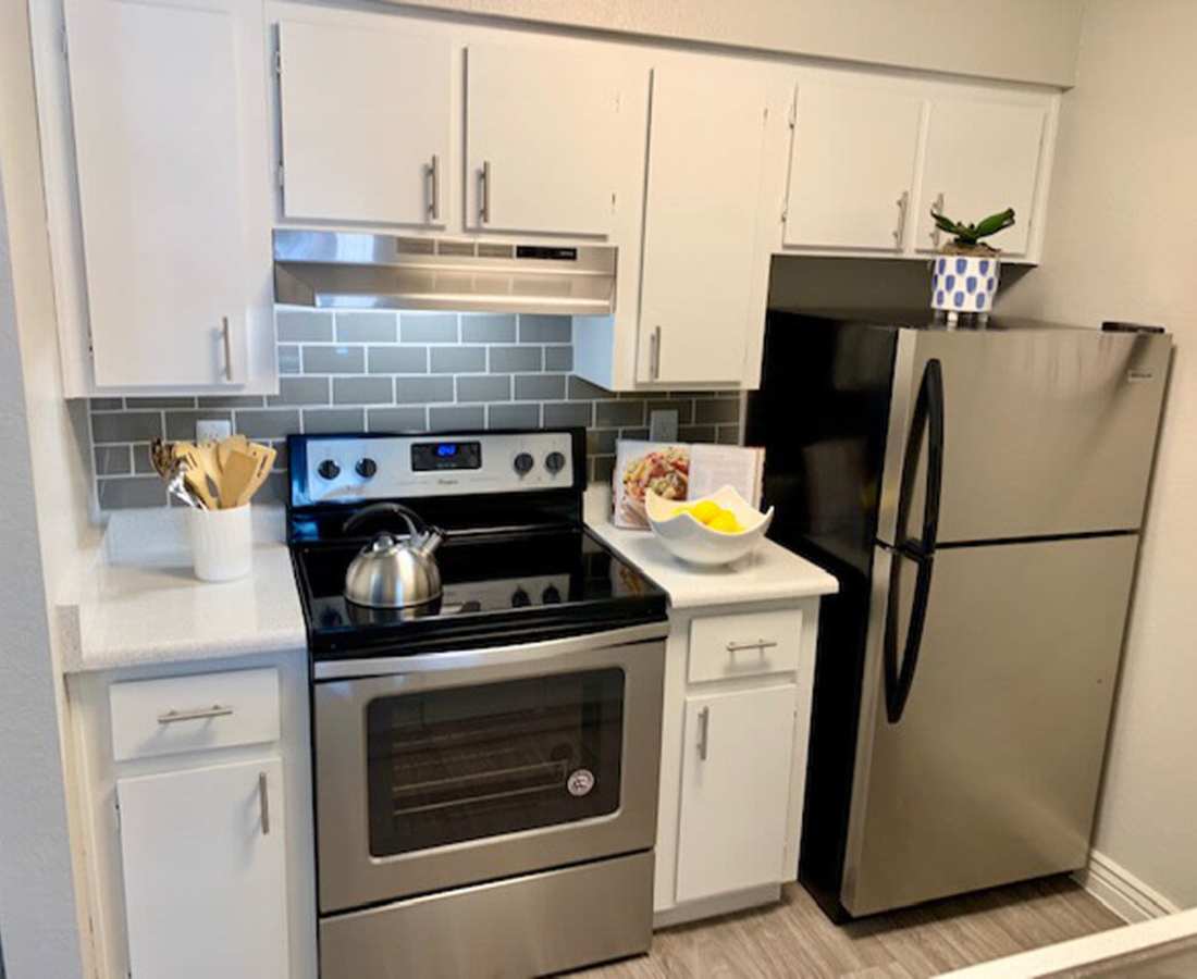 Kitchen with modern cabinetry, refrigerator and other appliances at 544 Southern Apartments in Mesa, Arizona