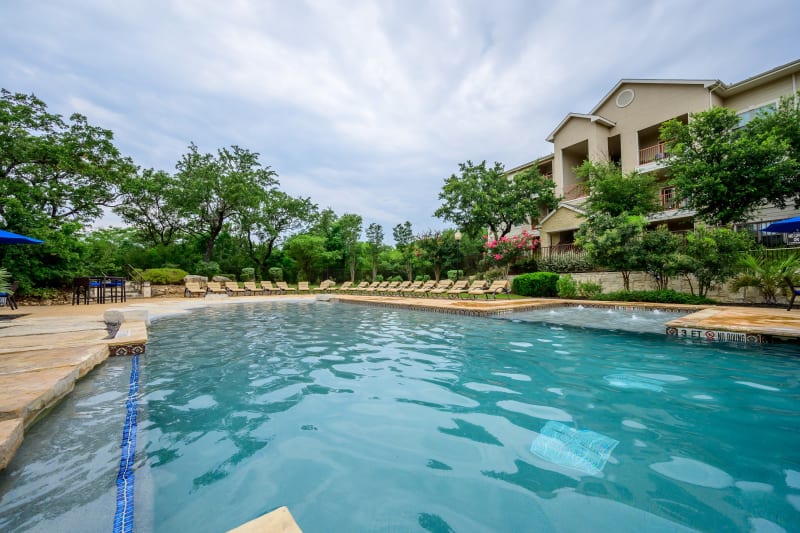 Poolside lounge chairs at Pecan Springs Apartments in San Antonio, Texas