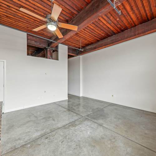 Unfurnished living room with ceiling fan and way to hallway at Stadium Loft Apartments in Saint Louis, Missouri