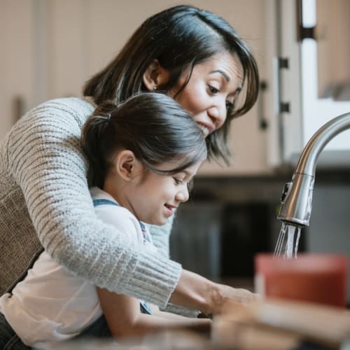 A mother and daugther washing their hands in a kitchen at Heroes Manor in Tarawa Terrace, North Carolina