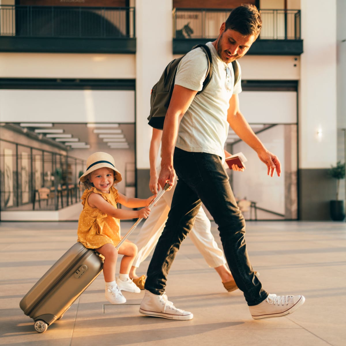 Father and daughter walking through an airport near Viva Communities