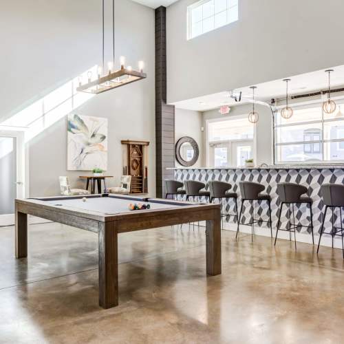 Clubhouse game room with pool table and bar seating at Magnolia South in Holly Springs, North Carolina