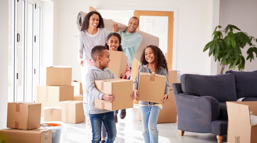 A family carrying storage boxes into their new home near KO Storage in Rindge, New Hampshire