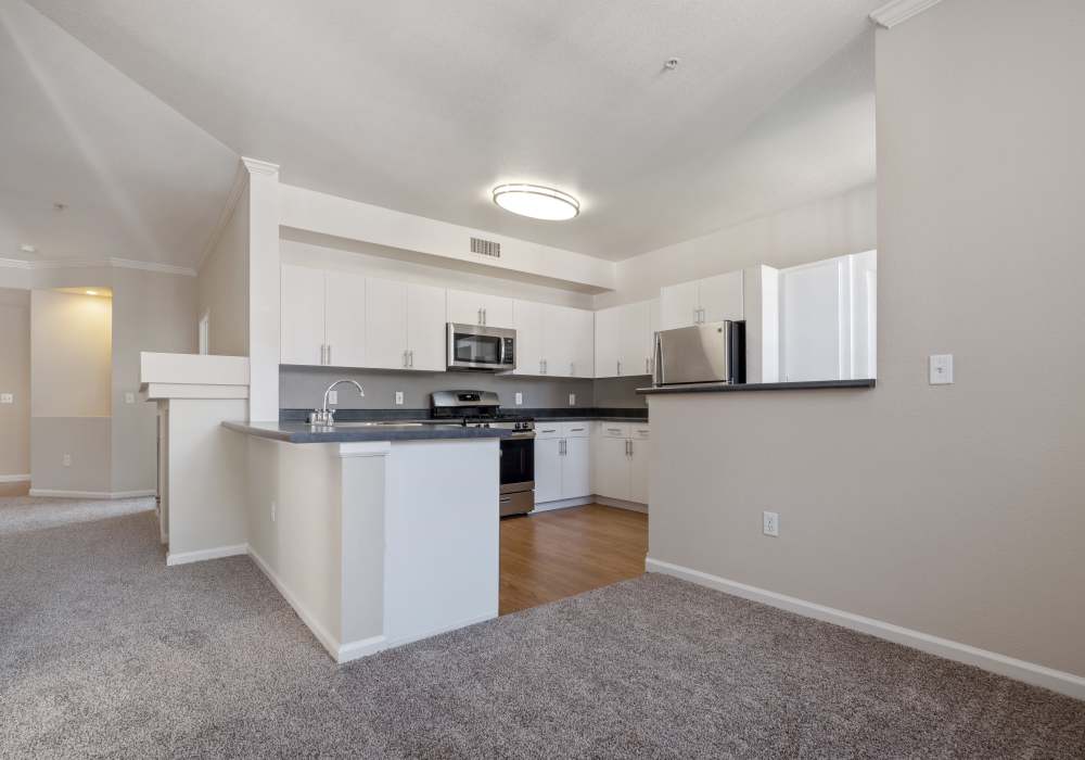 Open-concept of kitchen and living room at Park Hacienda Apartments in Pleasanton, California