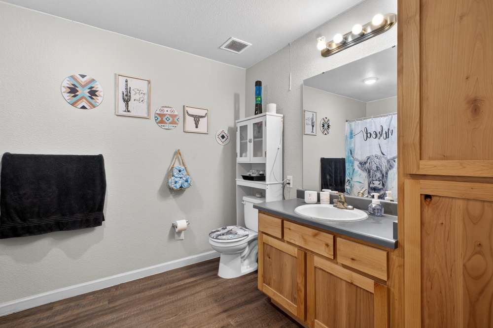 Cozy bathroom with rustic wooden accents and charming decor at Lakewood Crossing in Granbury, Texas.