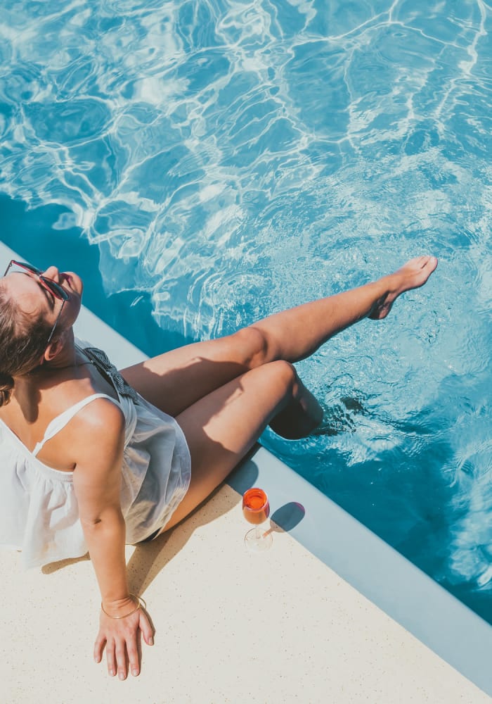 Woman sitting by the pool at The Residences at Promontory in Plano, Texas