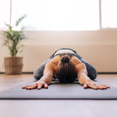 Resident doing yoga in the comfort of their living room at Bidwell Park Fremont in Fremont, California