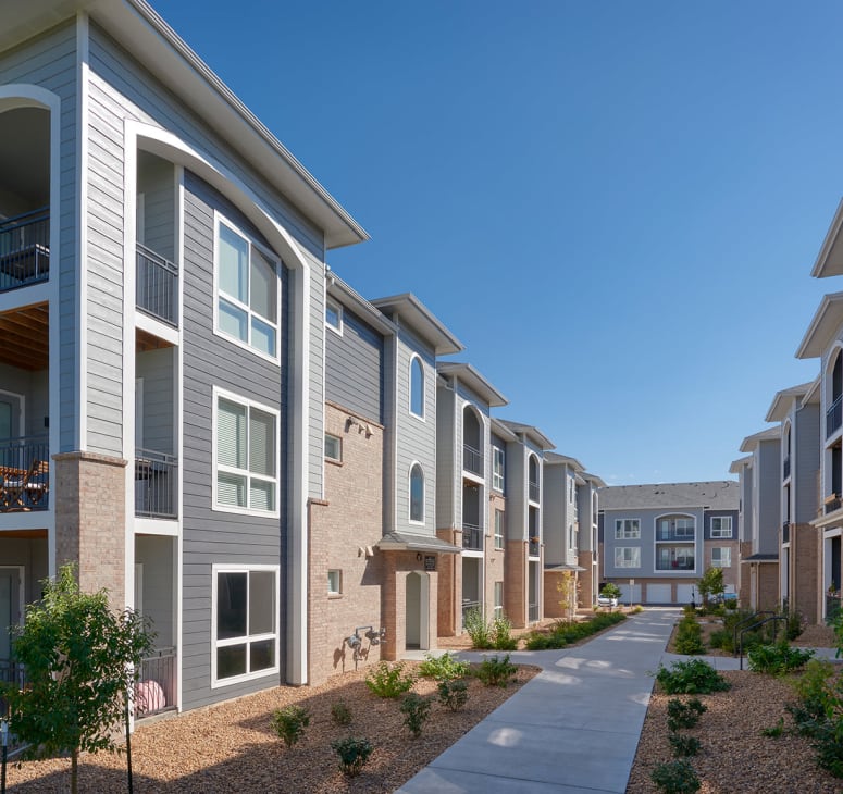 Exterior photo of homes and a walking path at Hawthorne Hill Apartments in Thornton, Colorado