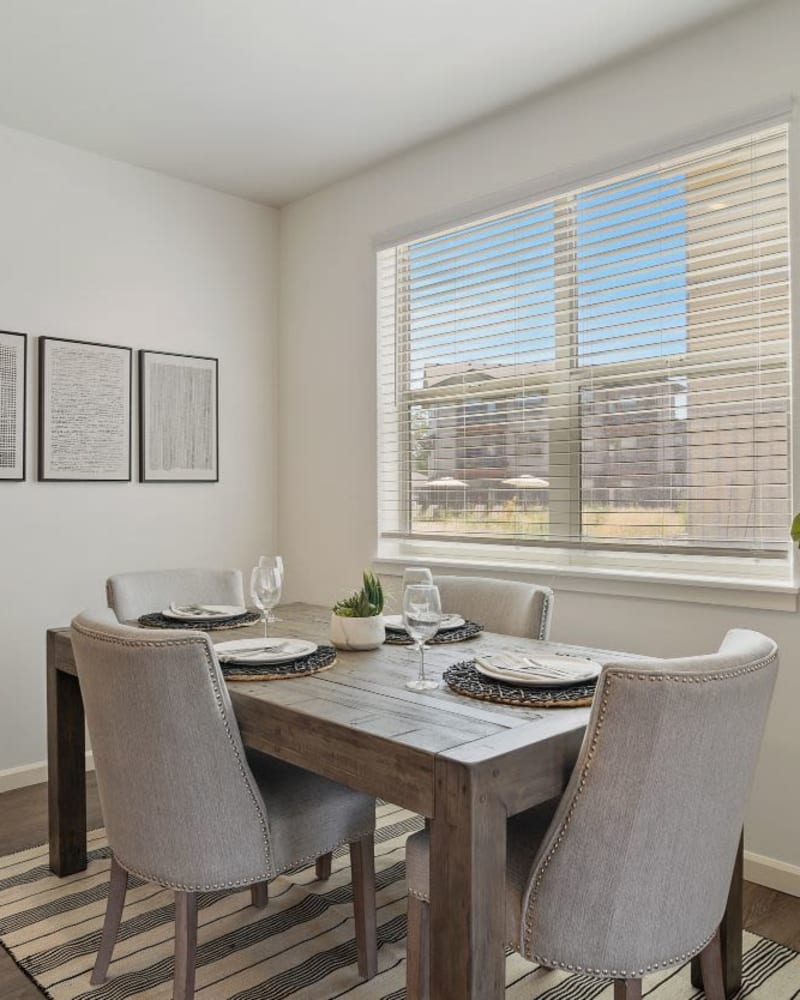 Model dining room with grayish furniture at The Jory Apartments in Salem, Oregon