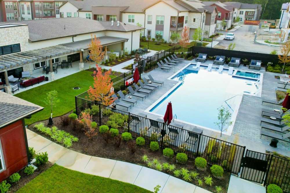 Bird’s‑eye view of fenced pool area with lounge chairs and landscaped paths at Apex at Perry Crossing in Plainfield, Indiana  