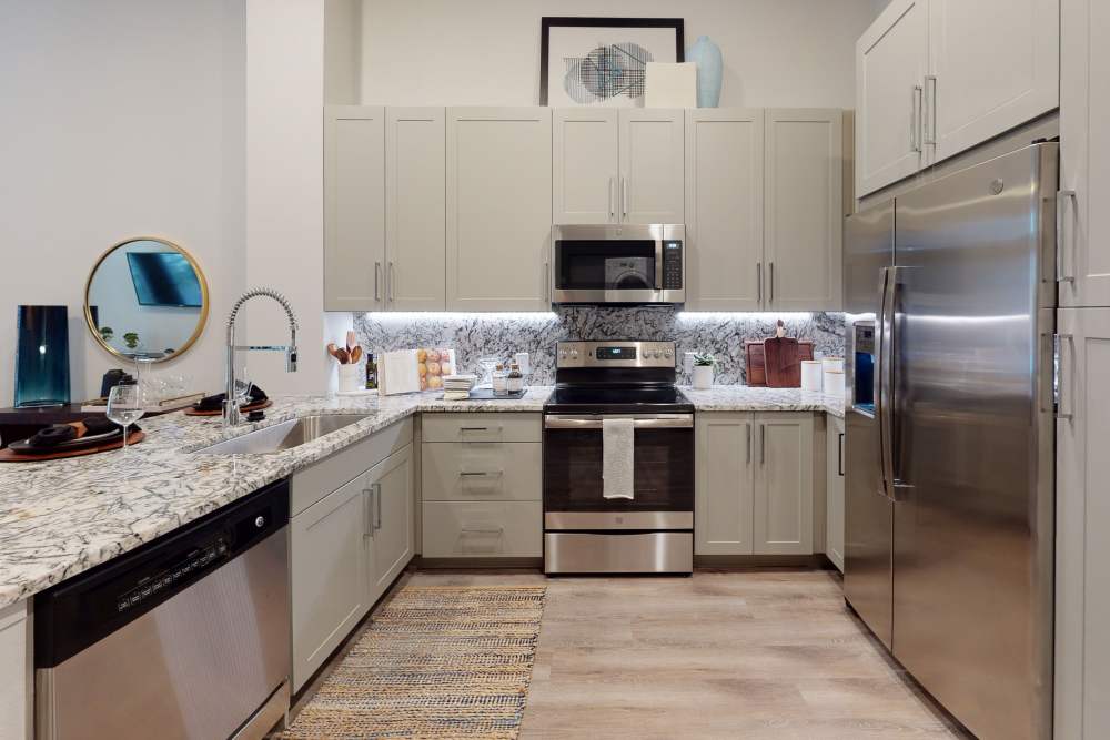 Cozy kitchen with refrigerator, range and dishwasher at Cornell Midtown in Dallas, Texas
