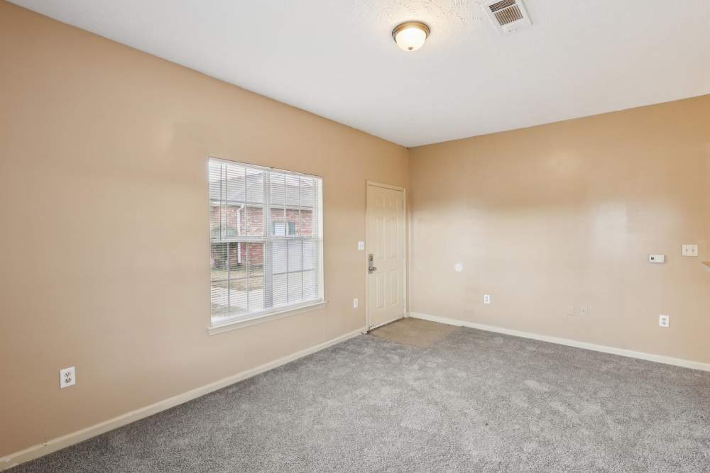 Living room with carpet flooring and large window at Camden Park in Canton, Mississippi