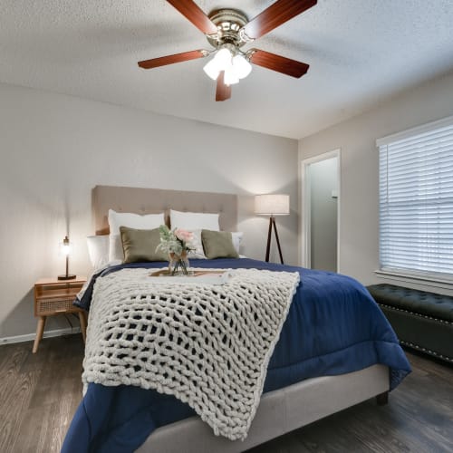 A bedroom with wood-style flooring and a ceiling fan at The Sage at 1955 in San Antonio, Texas