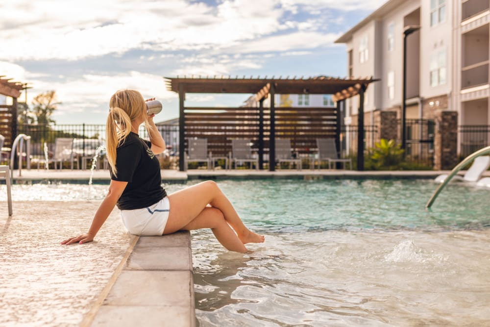 A resident lounges by the resort-style pool at The Waters at Settlers Trace in Lafayette, Louisiana