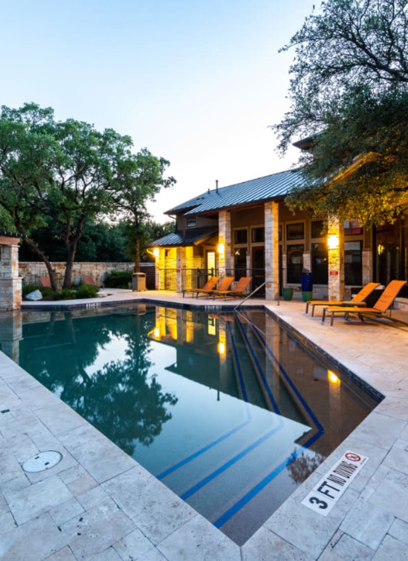Pool area with lounge chairs at sunset at Marquis at Barton Trails in Austin, Texas