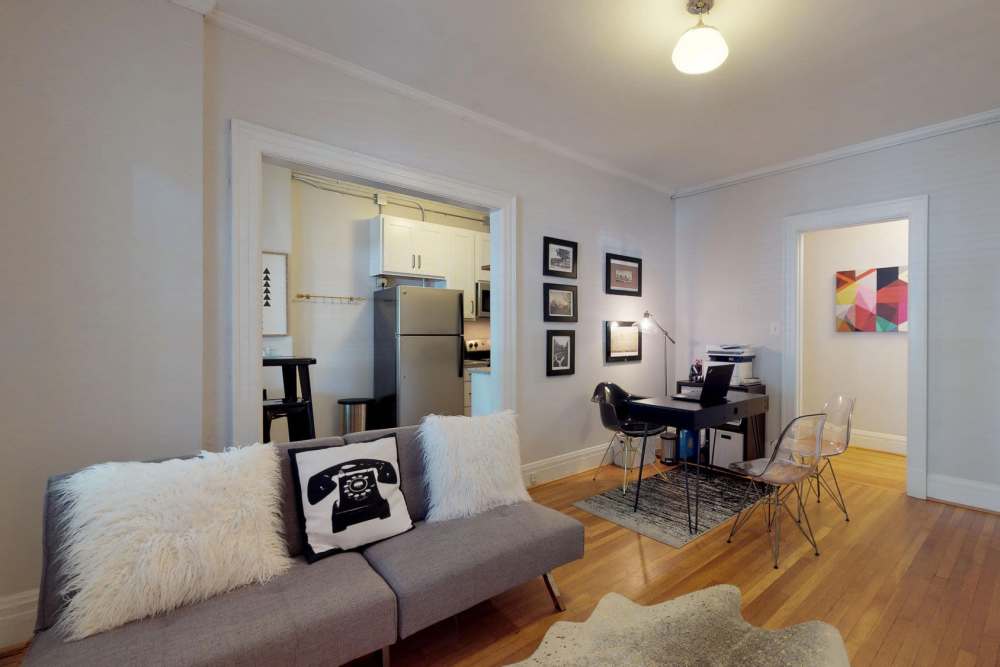 Living room with couch and oak wood flooring at Historic Boylan Apartments in Raleigh, North Carolina