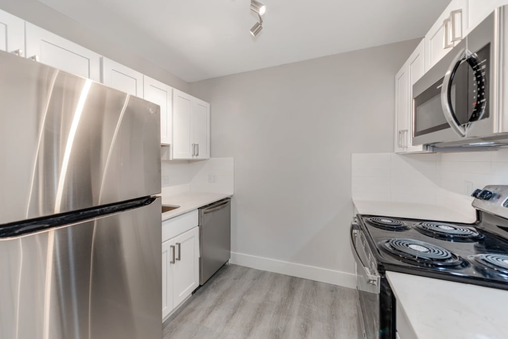 Kithcen with white cabinets and granite style countertops at The Flats at Arrowood in Charlotte, North Carolina