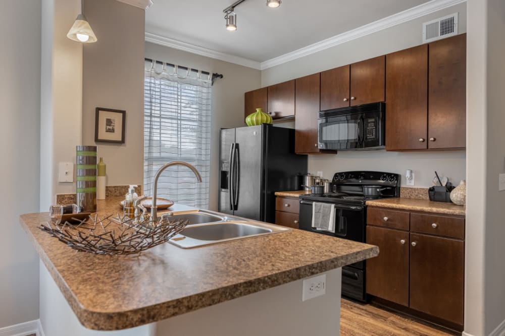 Kitchen with modern appliances and granite counters at Marquis at Sugar Land in Sugar Land, Texas