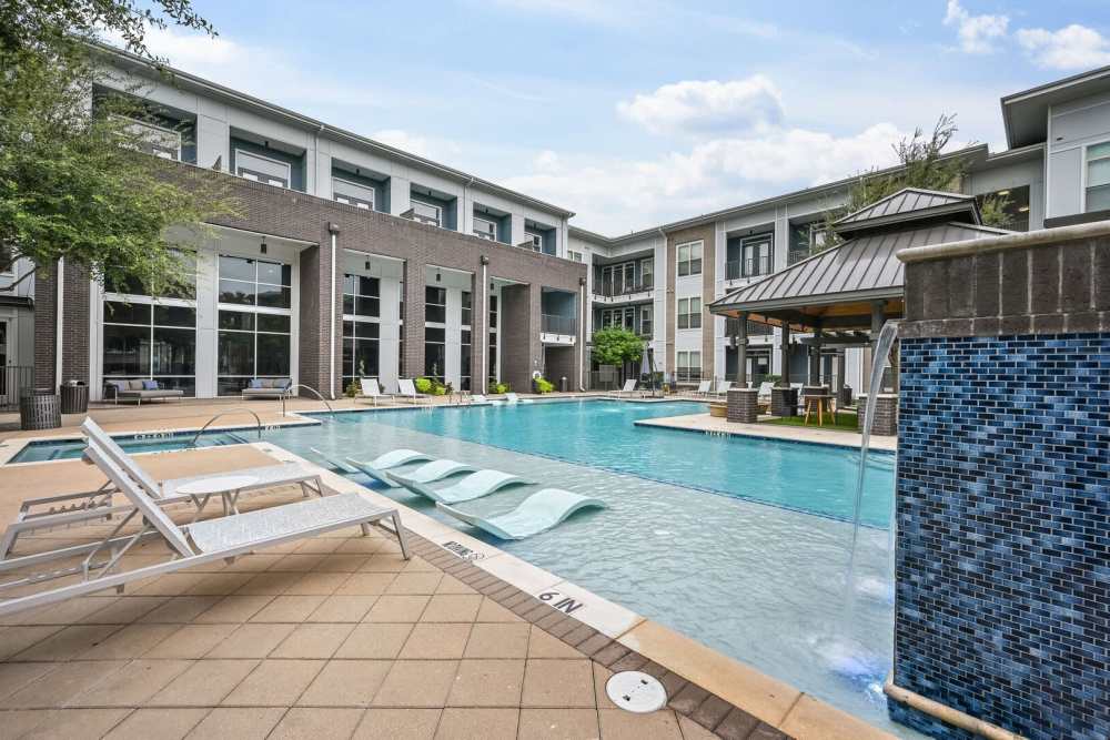Large swimming pool with lounge chair at Kade in Dallas, Texas