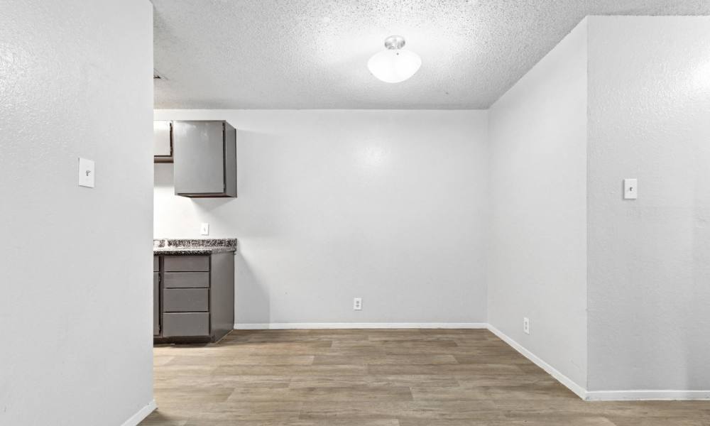 Apartment living area with wood flooring beside the kitchen at Arbors of Taylor in Taylor, Texas