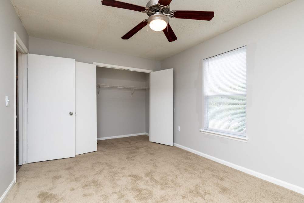 Unfurnished bedroom with ceiling fan and closet at West Village Apartments in Hillsborough, North Carolina