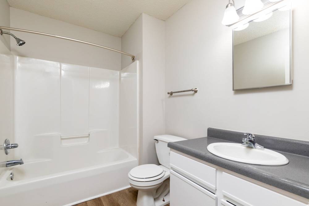 Bright bathroom with sink, commode and bathtub at West Village Apartments in Hillsborough, North Carolina