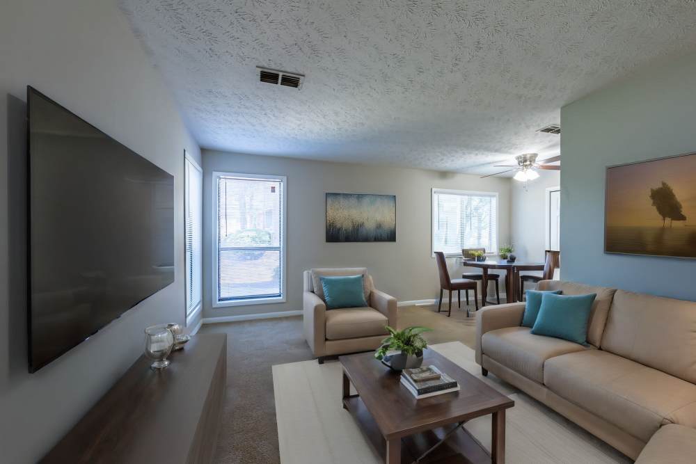 Modern living room large couch, chairs, window and flat screen television at Landmark Flats in Fayetteville, North Carolina
