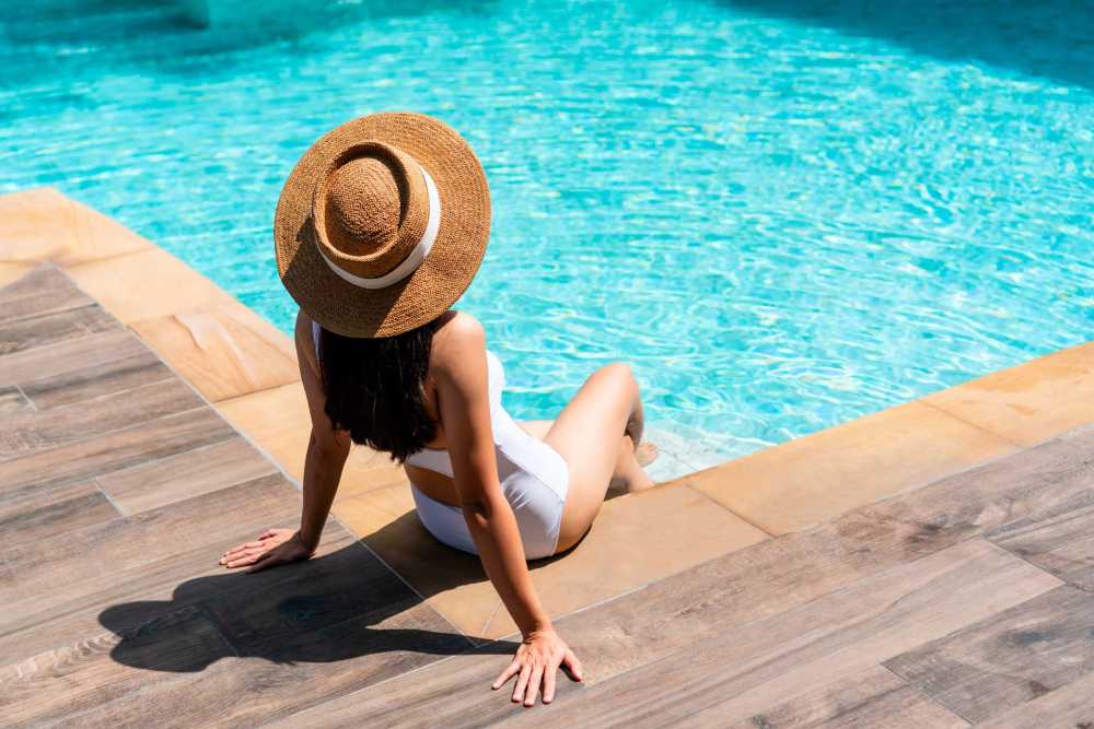 Resident relaxing at the pool's edge at Creekwood Apartments in Gainesville, Florida