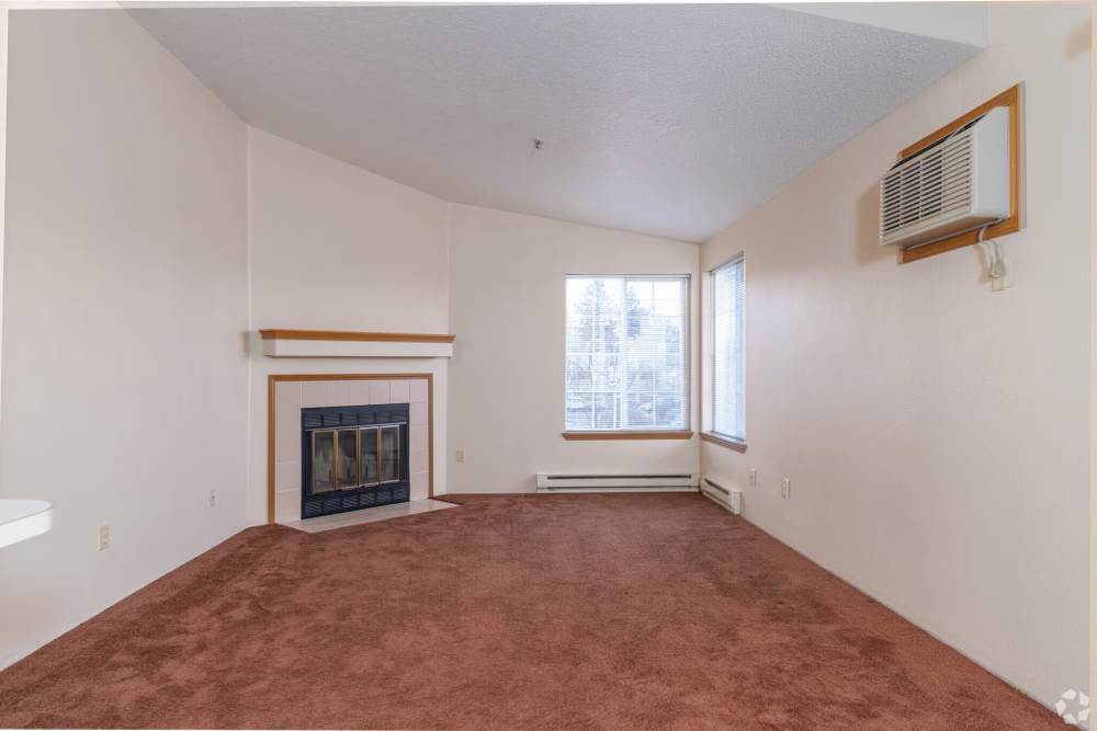 Spacious living room with fire place and large windows at Stonecrest Apartments in Spokane, Washington
