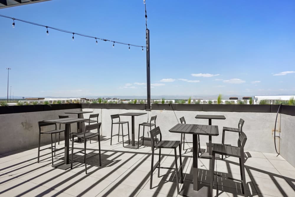 Outdoor patio with tables, string lights, and mountain view at Tempo at Nine Mile Station in Aurora, Colorado