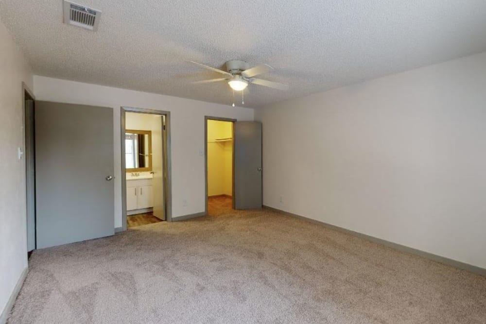 Cozy bedroom with a walk-in closet and bathroom at The Haylie in Garland, Texas