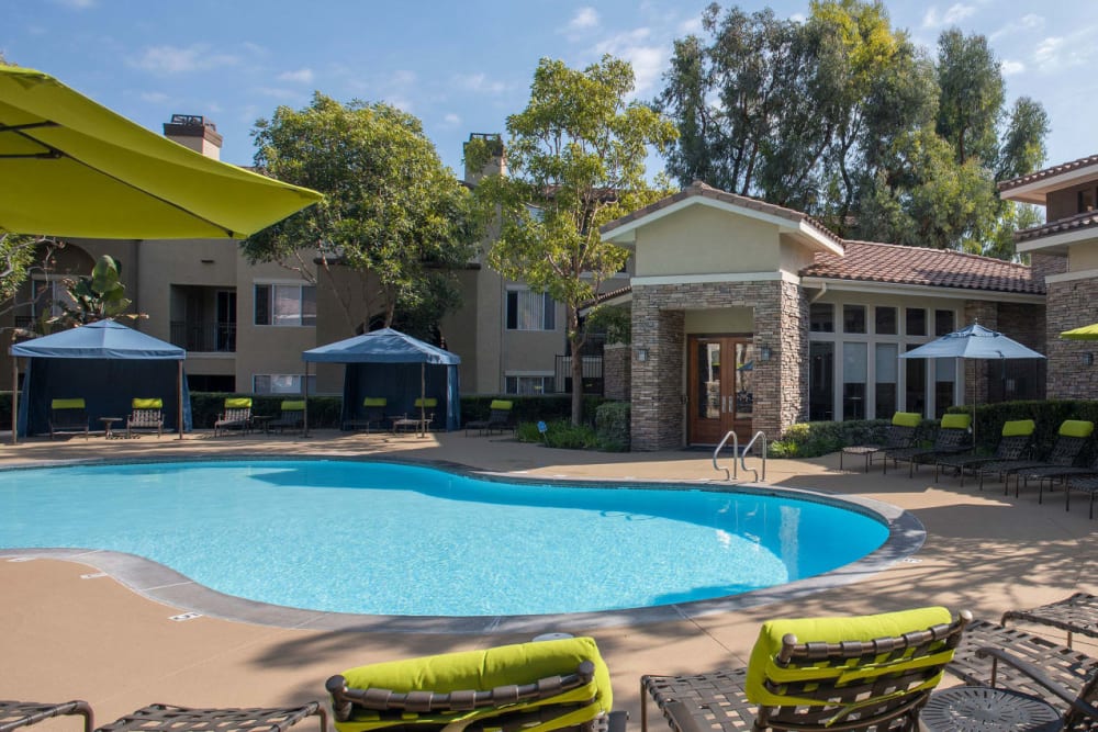 Swimming pool with a large sundeck and plenty of lounge chairs at Alize at Aliso Viejo Apartment Homes in Aliso Viejo, California