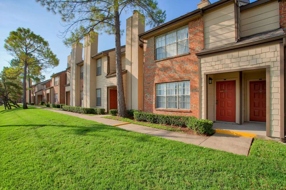Exterior of the apartment with green lawn at The Pines of Palos Verdes in Mesquite, Texas