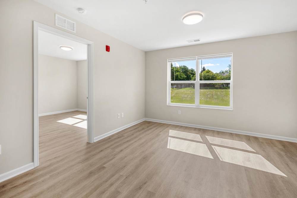 Spacious living room of apartment with window at Deville Manor in Oswego, Illinois