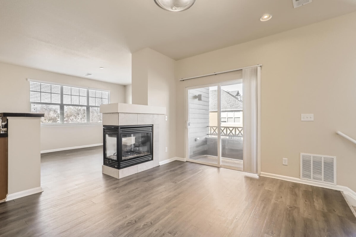 Wood-style flooring in a townhome living room with a fireplace at Maple Leaf Townhomes in Arvada, Colorado